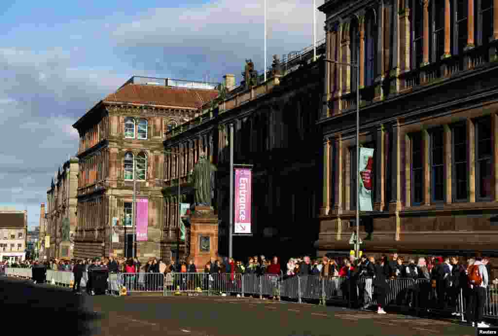 People wait in a queue outside St. Giles' Cathedral to view Queen Elizabeth lying in state, following the Queen's death, in Edinburgh, Scotland.
