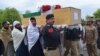 Relatives and security officials carry a coffin of one of the policeman who was killed by a roadside bomb in Lakki Marwat district of Khyber Pakhtunkhwa province on March 30, 2023.