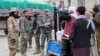Pakistan's border police check the papers of Afghan people before they cross into Pakistan at the zero point Torkham border crossing between Afghanistan and Pakistan, in Nangarhar province, Feb. 25, 2023.