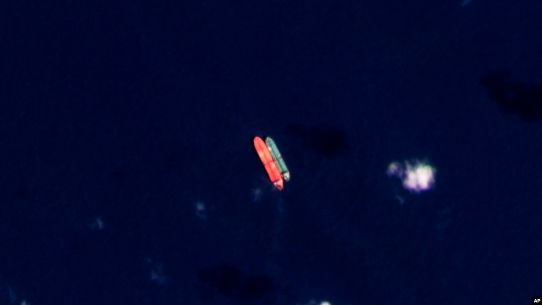 FILE - In this satellite photo, vessels identified as the Virgo, left, and the Suez Rajan are seen in the South China Sea on Feb. 13, 2022. For months, the Suez Rajan sat in the sea before suddenly sailing for the Texas coast without explanation. (Planet Labs PBC via AP)