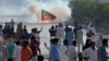 FILE - Supporters of Pakistan's former Prime Minister Imran Khan block a road as police fire tear gas to disperse them during a protest in support of Khan in Karachi, Pakistan, May 9, 2023. 