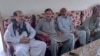 People offer their support to Raja Tariq, left, whose son Raja Awais is missing after a shipwreck off the Greek coast, in Bindian village in Kotli, a district of Pakistan's administrator Kashmir, June 18, 2023. 