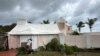 A man boards up a house to protect it from the approaching Hurricane Ernesto in Warwick, Bermuda, Aug. 16, 2024. 