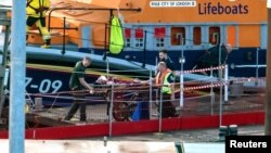 Rescuers assist a migrant after a boat carrying migrants from France sunk in the English Channel, in Dover, Britain, on Aug. 12, 2023.