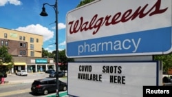 FILE - A sign advertises COVID-19 vaccine shots at a Walgreens Pharmacy in Somerville, Mass., Aug. 14, 2023. 