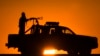 FILE - Afghan National Policemen (ANP) travel in their vehicle as the sun sets at Delaram district in Nimroz province, southern Afghanistan, Jan. 24, 2010. 