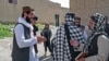 FILE - Taliban-trained suicide bomber Ismail Ashuqullah (L) speaks with Taliban's General Directorate of Intelligence (GDI) after an interview with AFP in Otarhi village in Tangi valley of Saydabad district, Maidan Wardak province, May 25, 2023. 