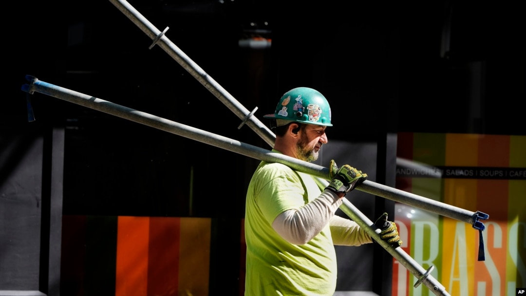 FILE - A construction worker carries scaffolding parts on March 14, 2024, in Boston. The unemployment rate jumped to 4.3% in July, the fourth consecutive month the rate has increased and the highest since Oct. 2021.
