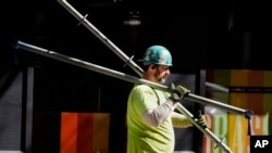 FILE - A construction worker carries scaffolding parts on March 14, 2024, in Boston. The first job report of Donald Trump’s second presidency suggested that he inherited a labor market that is solid but unspectacular.