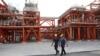 FILE - Two Iranian technicians walk at a natural gas refinery at the South Pars gas field, in Asaluyeh, Iran, March 16, 2019. Pakistan plans to barter with Iran, Afghanistan and Russia for goods such as petroleum and gas, in order to bypass Western sanctions. 