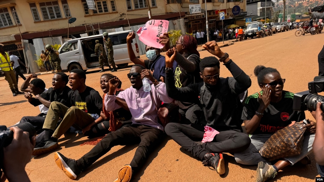 Chanting protesters sit in the middle of the road during protests in Kampala, Uganda, on July 23, 2024. (Halima Athumani/VOA)
