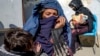 FILE - Mothers with malnourished babies wait for help at a World Food Program clinic in Kabul, Afghanistan, Jan. 26, 2023.