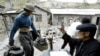FILE - A Chinese villager weighs antimony ore he collected from an illegal mine at Lengshuijiang in China's southern province of Hunan Aug. 10, 2003. 