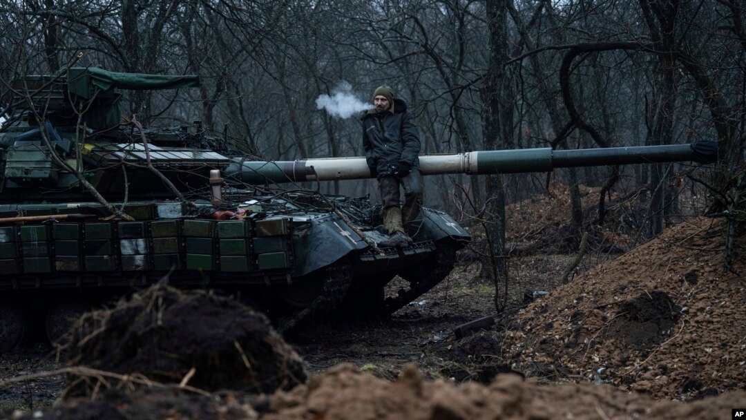 A Ukrainian serviceman smokes a cigarette while standing on top of a tank near Bakhmut, Ukraine, March 8, 2023. 