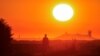 FILE - A migrant walks back to his makeshift camp at sunrise after a failed attempt to cross the Channel to the UK on a small boat, in Sangatte, near Calais, France, Aug. 10, 2023. 