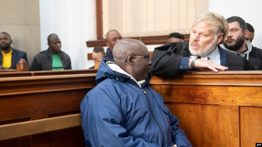 Fulgence Kayishema (kushoto) akizungumza na wakili wake Juan Smuts (kulia) katika Mahakama ya Cape Town, tarehe 26 Mei 2023. Picha na RODGER BOSCH / AFP. 