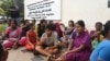 Relatives of the victims killed in a fire triggered by an explosion at the Escientia Advanced Sciences Private Ltd., a pharmaceutical company, sit outside the factory, in Atchutapuram, Andhra Pradesh state, India, Aug. 22, 2024. 