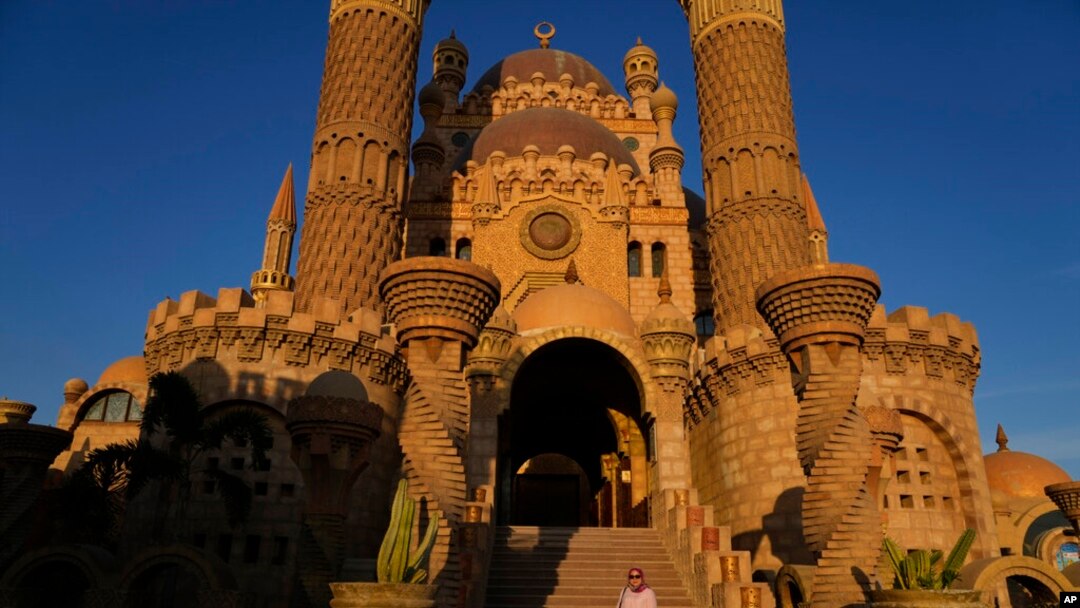 A woman poses for a picture on the stairs of the Al Sahaba mosque in in Sharm el-Sheikh, Egypt, Nov. 5, 2022. 