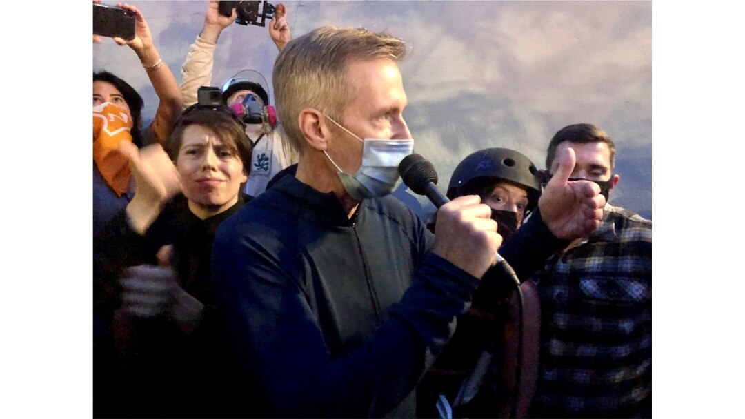 FILE - Mayor Ted Wheeler speaks to people gathered in downtown Portland, Oregon, July 22, 2020.