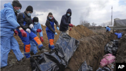 지난달 9일 우크라이나 남동부 항구도시 마리우폴 외곽에서 검은 비닐에 싸인 시신들을 주민들이 매장하고 있다. 