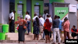 FILE - People queue at ATMs in Abuja, Nigeria, March 30, 2020.