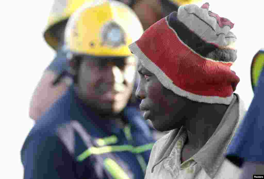 A suspected illegal miner is led away after being rescued from an abandoned gold shaft in Benoni, east of Johannesburg, South Africa, Feb. 16, 2014.