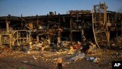 A man sweeps rubble next to a shopping and entertainment mall destroyed after a Russian missiles strike on May 9, in Odesa, Ukraine, May 13, 2022. 