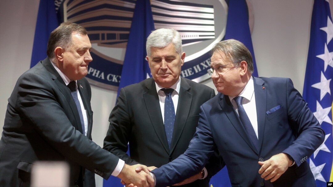 Bosnian Serb leader Milorad Dodik, left and Bosniac leader Nermin Niksic shake hands in Sarajevo, Bosnia, Dec. 15, 2022. Three diplomats told The Associated Press that Bosnia has been granted candidate status into the European Union.