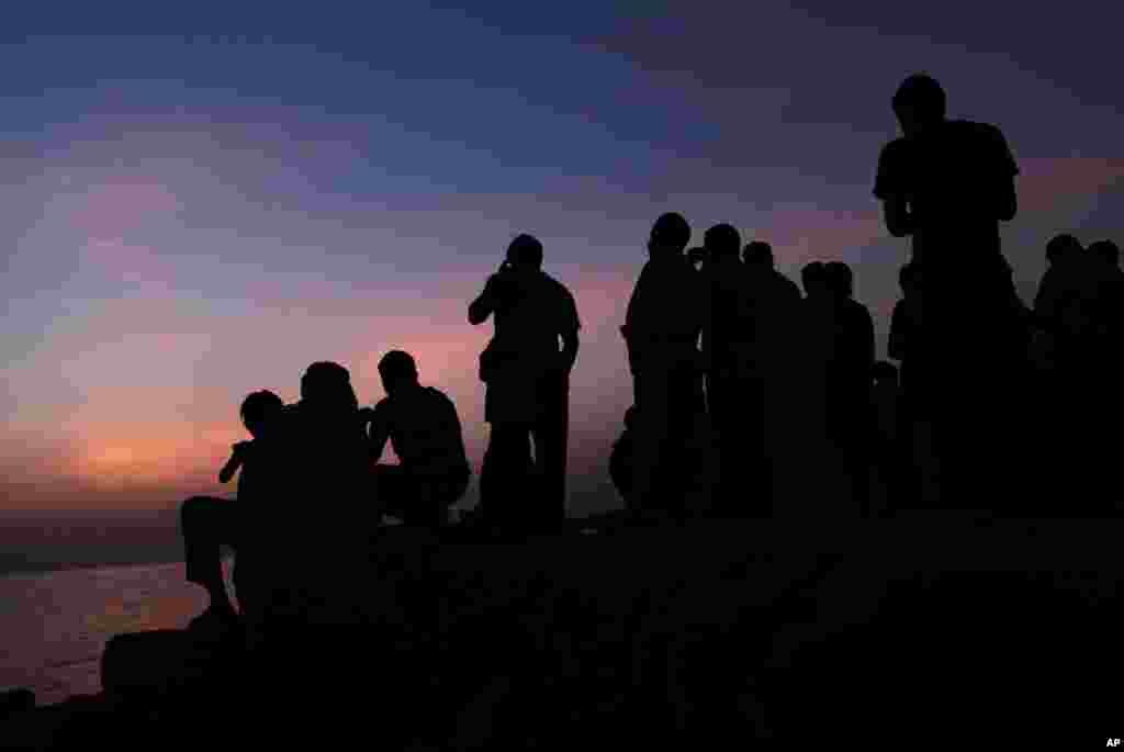 Bahraini men gather to search the sky over the Persian Gulf for the crescent moon in the western village of Karzakan, Bahrain, July 9, 2013.
