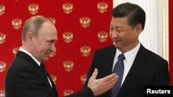 普京与习近平互动资料照。
