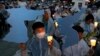 Participants hold candles and cardboard cutouts of the map of Korean Peninsula during a rally wishing for a successful Trump-Kim summit, near the U.S. embassy in Seoul, South Korea, June 9, 2018.