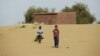 Boys walk on desert sands in the town of Moghtar-Lajjar in west Africa's Sahel region, where the United Nations says civil unrest and a drought have put 18 million people in food insecurity, May 25 2012.