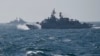 FILE - The Turkish warship TCG Turgutreis, foreground, maneuvers on the Black Sea after leaving the port of Constanta, Romania, March 16, 2015.