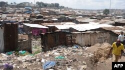 FILE - A man walks by the slum of Mathare in Nairobi, May 28, 2014. 