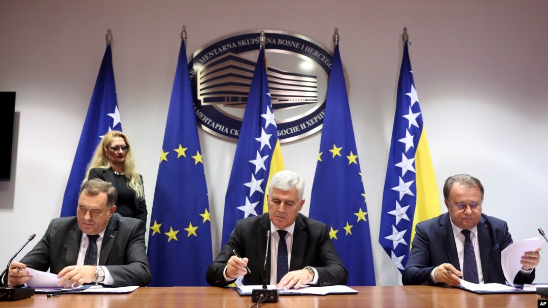 Bosnian Serb leader Milorad Dodik, left, Bosnian Croat leader Dragan Covic, center, and Bosniac leader Nermin Niksic sign a coalition document in Sarajevo, Bosnia, on Dec. 15, 2022.