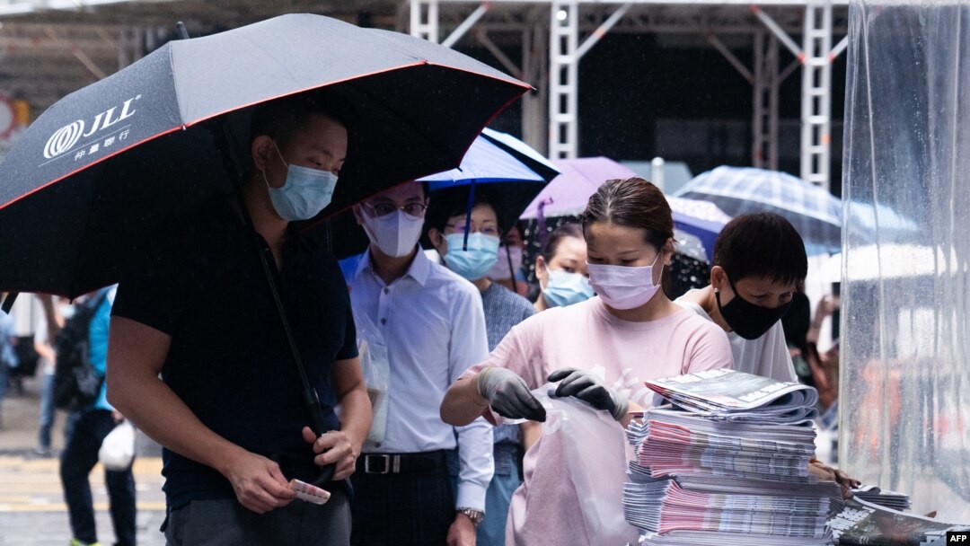 FILE - A man purchases a copy of the Apple Daily newspaper's final edition in Hong Kong's Central district on June 24, 2021, after the pro-democracy tabloid was forced to close after 26 years under a sweeping new national security law. 