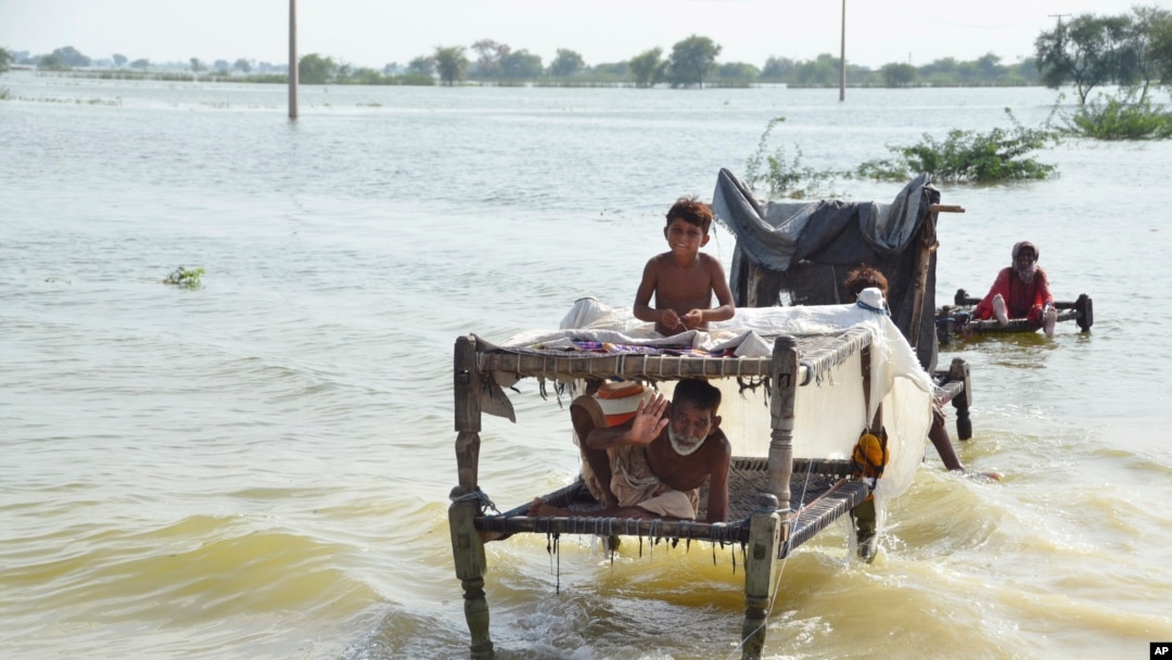 A man sits near his belongings surrounded by floodwaters, in Sohbat Pur city, a district of Pakistan's southwestern Baluchistan province, Sep. 3, 2022.