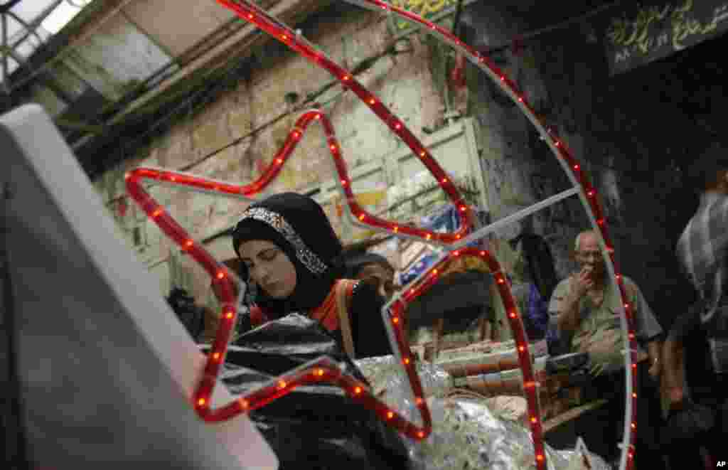 A Palestinian woman buys traditional Ramadan decorations at a market in the West Bank city of Nablus, ahead of Ramadan, July 9, 2013.