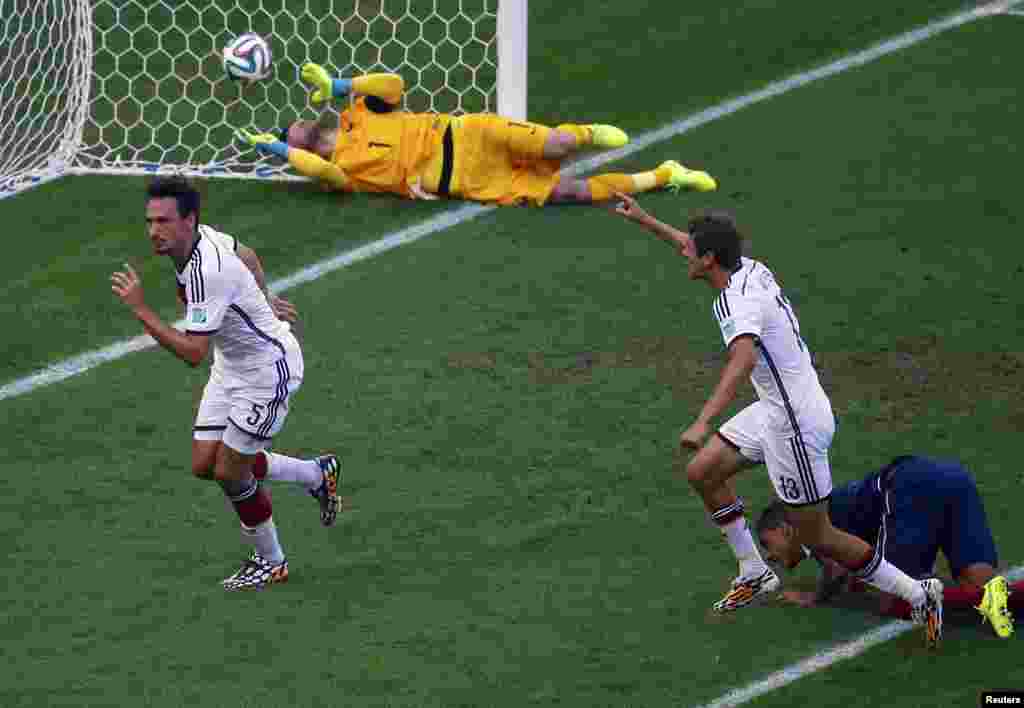 Germaniya o'yinchilari Tomas Muller va Mats Hummels Fransiya darvozasiga kiritilgan golni nishonlamoqda, 4-iyul, 2014-yil.