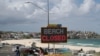People walk past a "Beach Closed" sign at Bondi Beach in Sydney, Australia, on April 1, 2020. The beach remains closed to prevent the spread of COVID-19.