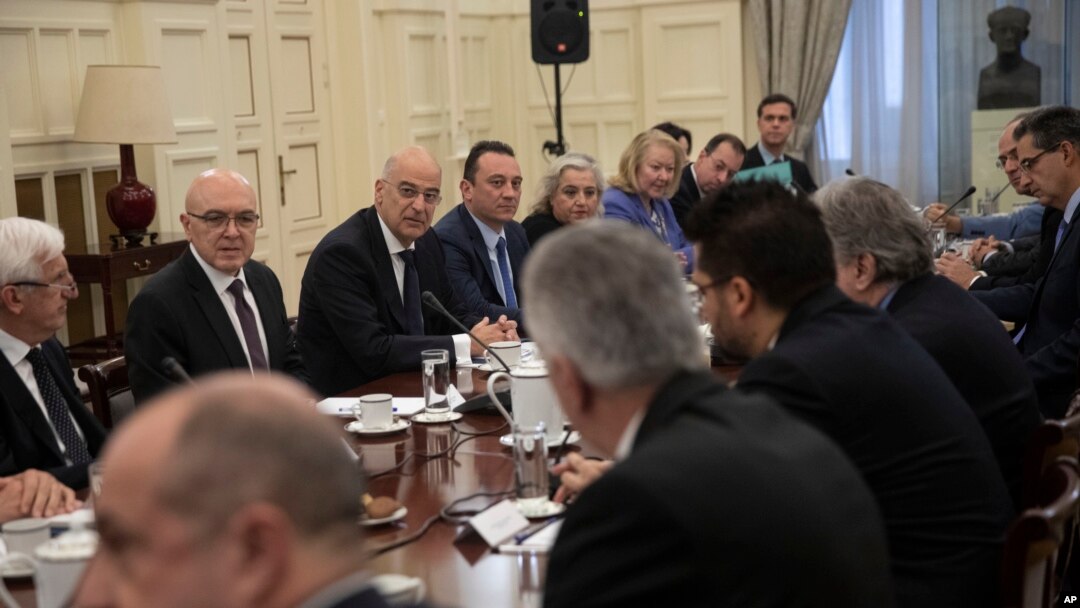 Greek foreign Minister Nikos Dendias, facing third left, takes part in a meeting with political party representatives on developments for the maritime boundary deal between Turkey and Libya in Athens, Dec. 10, 2019. 