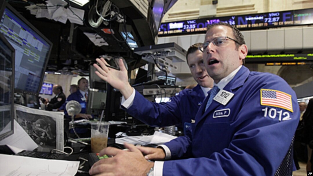 Michael Pistillo (R) works with a fellow specialist on the floor of the New York Stock Exchange, August 9, 2011
