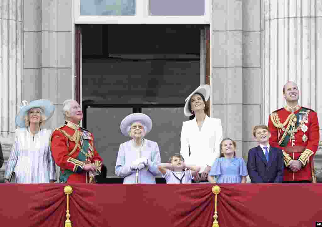 From left, Camilla, Duchess of Cornwall; Prince Charles; Queen Elizabeth II; Prince Louis; Catherine, Duchess of Cambridge; Princess Charlotte; Prince George; and Prince William watch from the balcony of Buckingham Place after the Trooping the Color ceremony in London, June 2, 2022, on the first of four days of celebrations to mark the queen's Platinum Jubilee. 