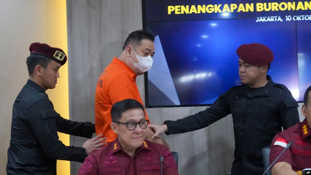 A suspected wanted by China for running a $14 billion investment scam, identified only by his initial LQ, is escorted by Indonesian immigration officers during a news conference in Jakarta, Indonesia, Oct. 10, 2024.