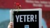 FILE - A member of the Journalists Union of Turkey holds a placard reading "Enough!" during a demonstration to mark World Press Freedom Day in central Istanbul, May 3, 2017. 