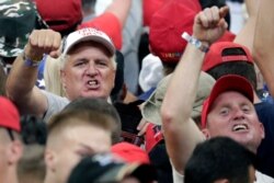 President Donald Trump supporters shake their fists at the media as Trump formally announced his 2020 re-election bid, June 18, 2019, in Orlando, Fla