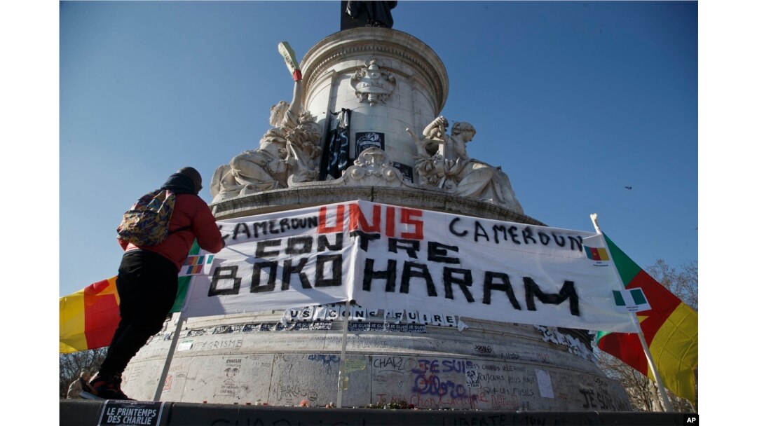 A Cameroonian man living in exile in France adjusts a banner that reads,"Cameroon united against Boko Haram," at the Republique plaza in Paris, Feb. 7, 2015.