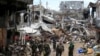 Government soldiers stand in front of damaged houses and buildings in Marawi city, Philippines, Oct. 25, 2017.