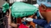 A health worker checks the temperature of a passenger, amid the spread of the coronavirus disease, at a railway station in Mumbai, India, March 17, 2021.
