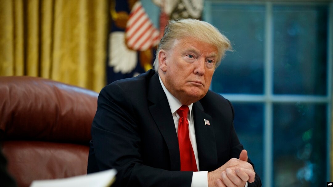 FILE - President Donald Trump listens to a question during an interview in the Oval Office of the White House, in Washington, Oct. 16, 2018.